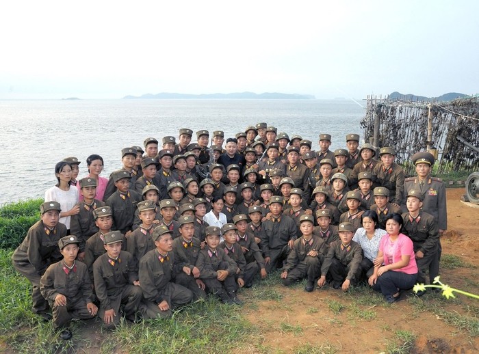 Nam nữ quân nhân Triều Tiên trên một hòn đảo chụp ảnh chung với nhà lãnh đạo Kim Jong Un - ảnh KCNA